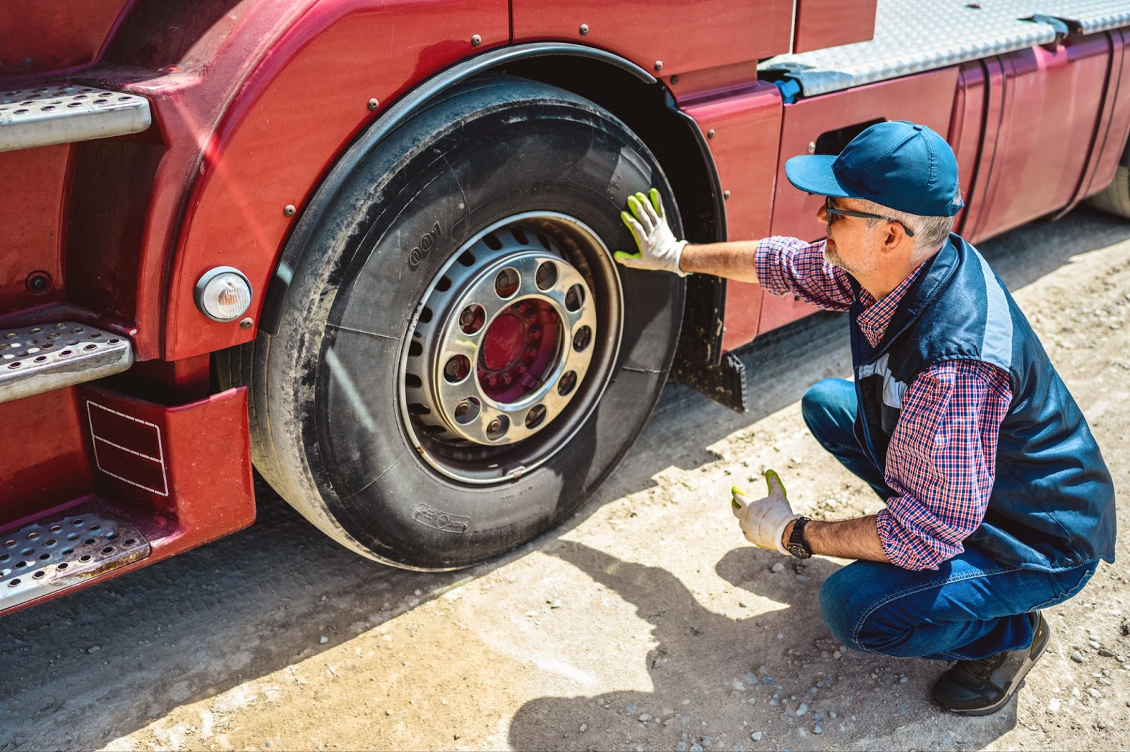 DOT inspector wearing a safety vest reviews a clipboard beside a truck.